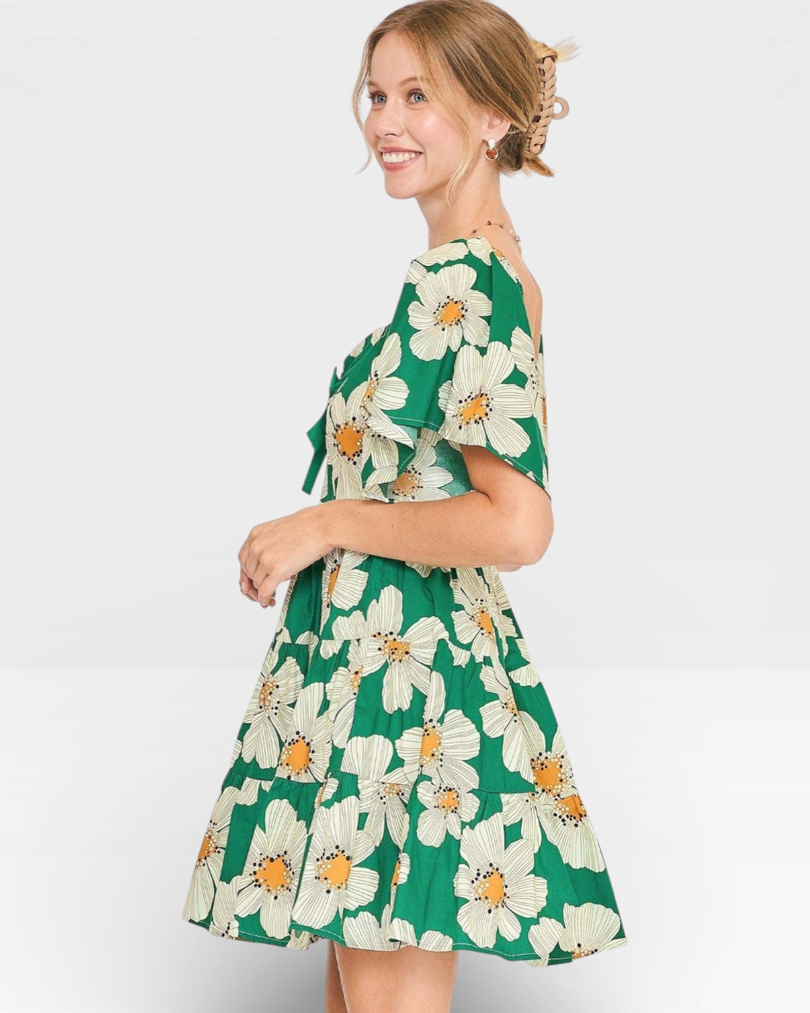 Woman wearing a green floral dress on a white background