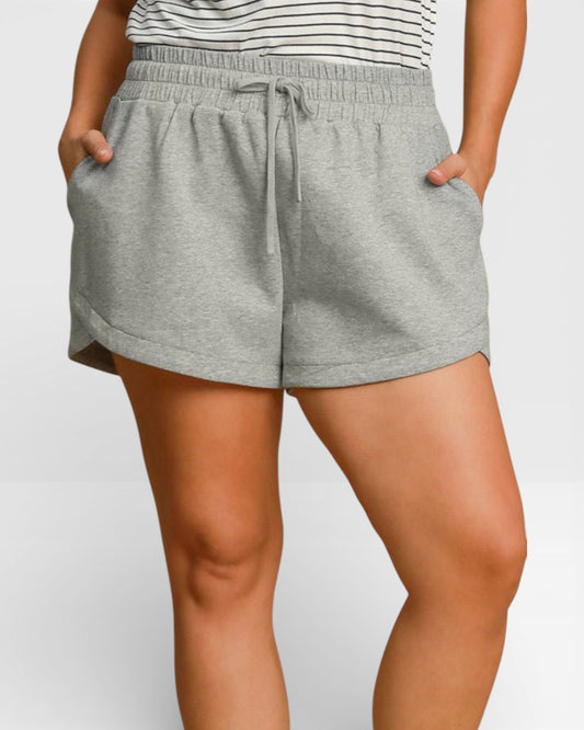 Person wearing gray shorts with a white background