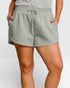Person wearing gray shorts with a white background