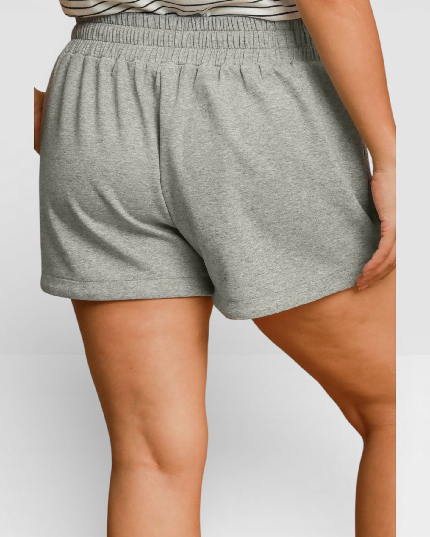Gray shorts worn by a person on a plain background