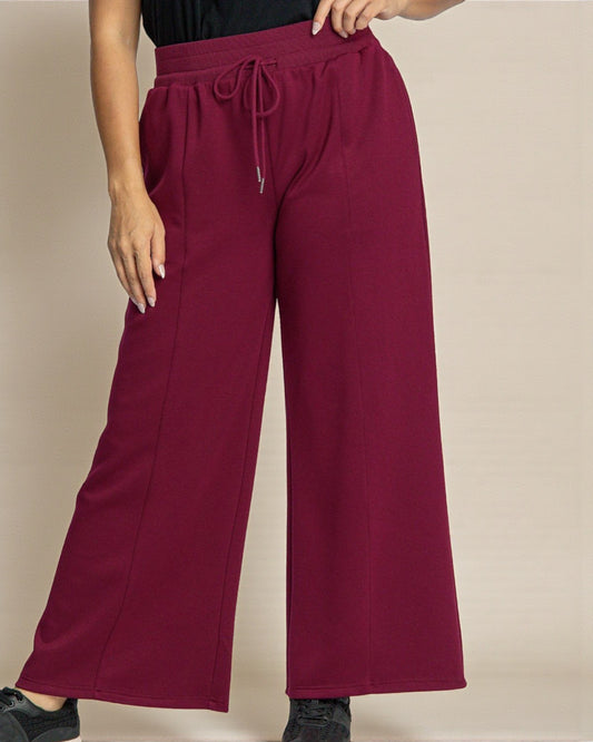Maroon wide-leg pants worn by a person on a beige background
