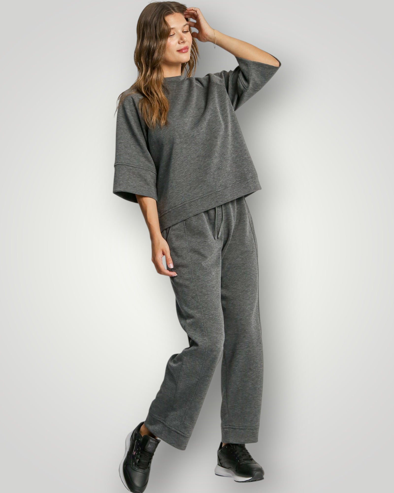 Woman wearing a gray outfit on a white background