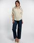 Woman wearing a beige blouse and navy pants on a white background