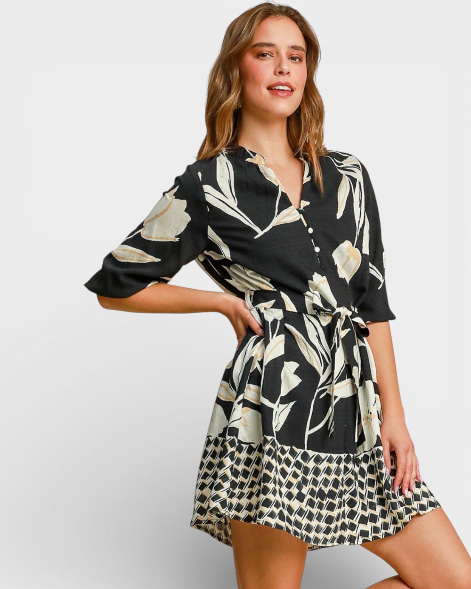 Woman wearing a black and white patterned dress on a plain background