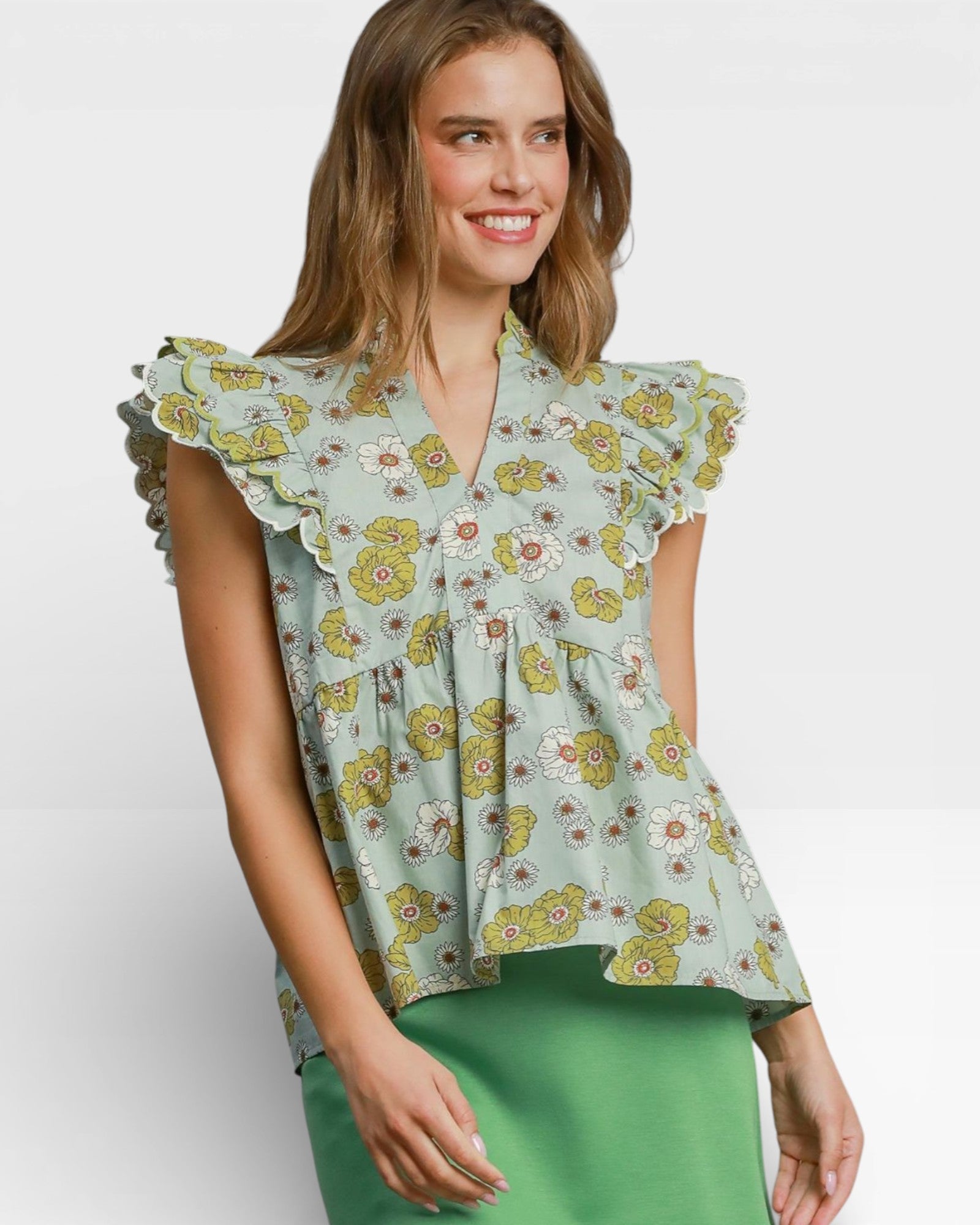 Woman wearing a floral blouse with ruffled sleeves on a white background