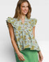 Woman wearing a floral blouse with ruffled sleeves on a white background