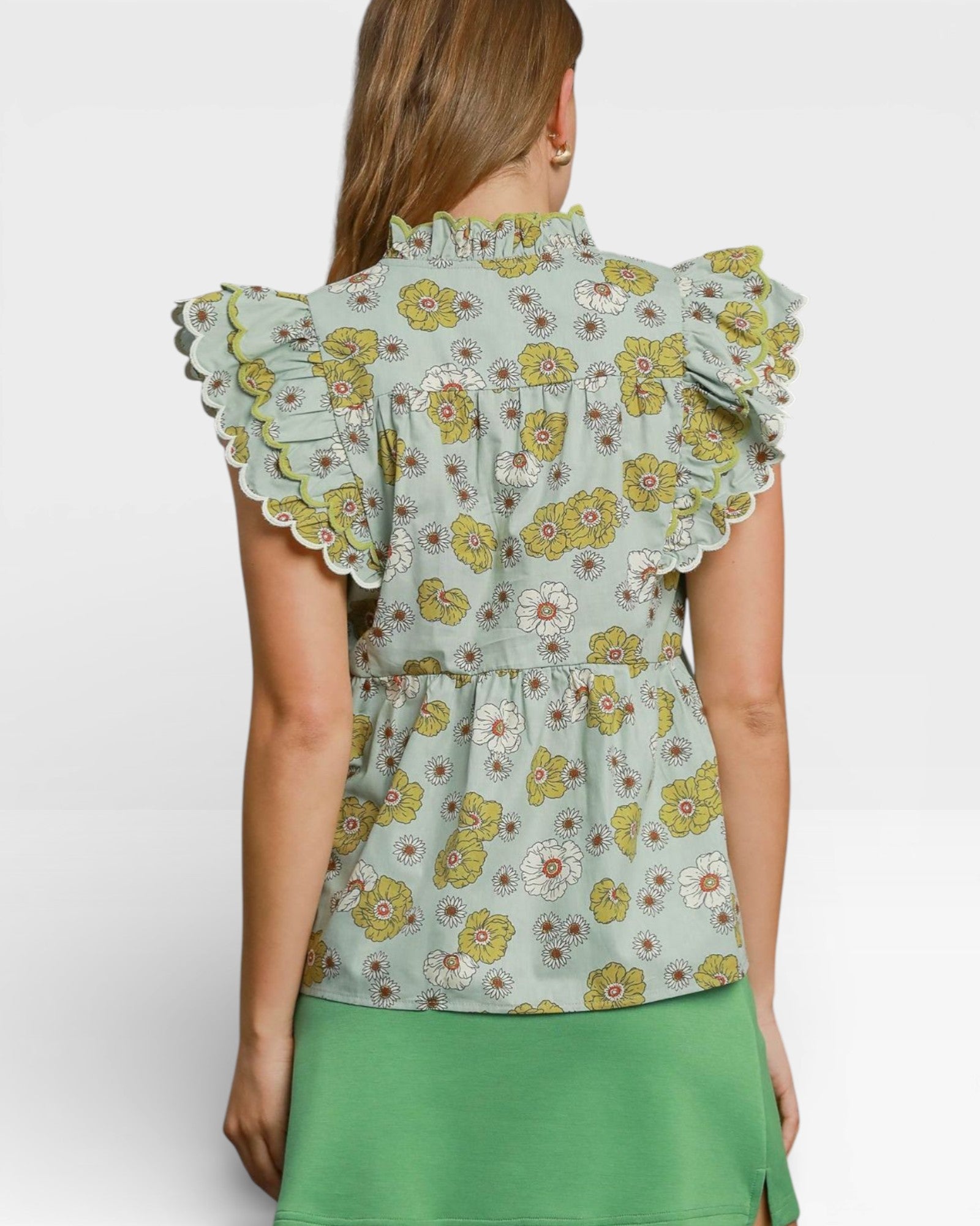 Woman wearing a floral blouse with ruffled sleeves on a white background