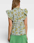Woman wearing a floral blouse with ruffled sleeves on a white background