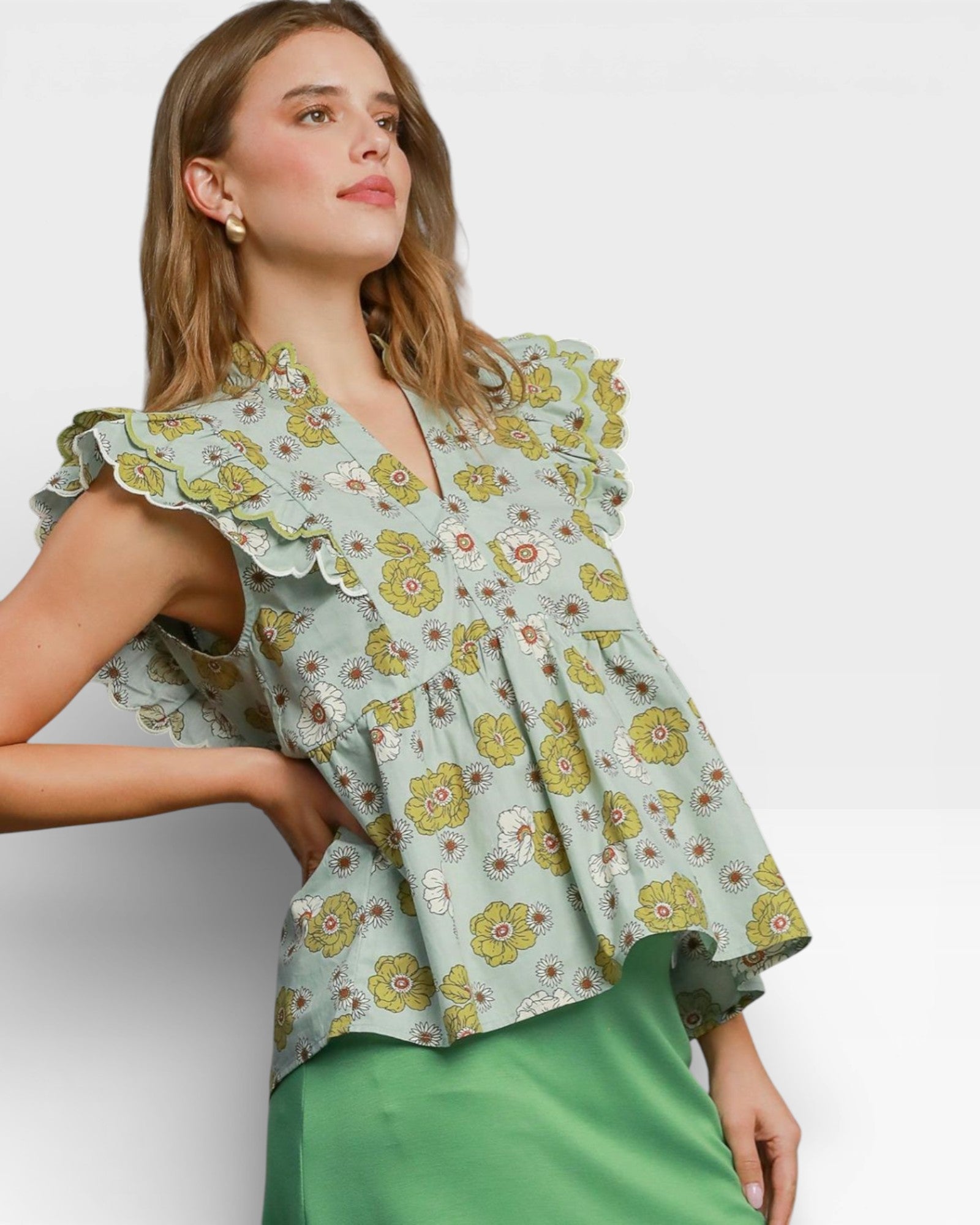 Woman wearing a floral blouse with ruffled sleeves on a white background