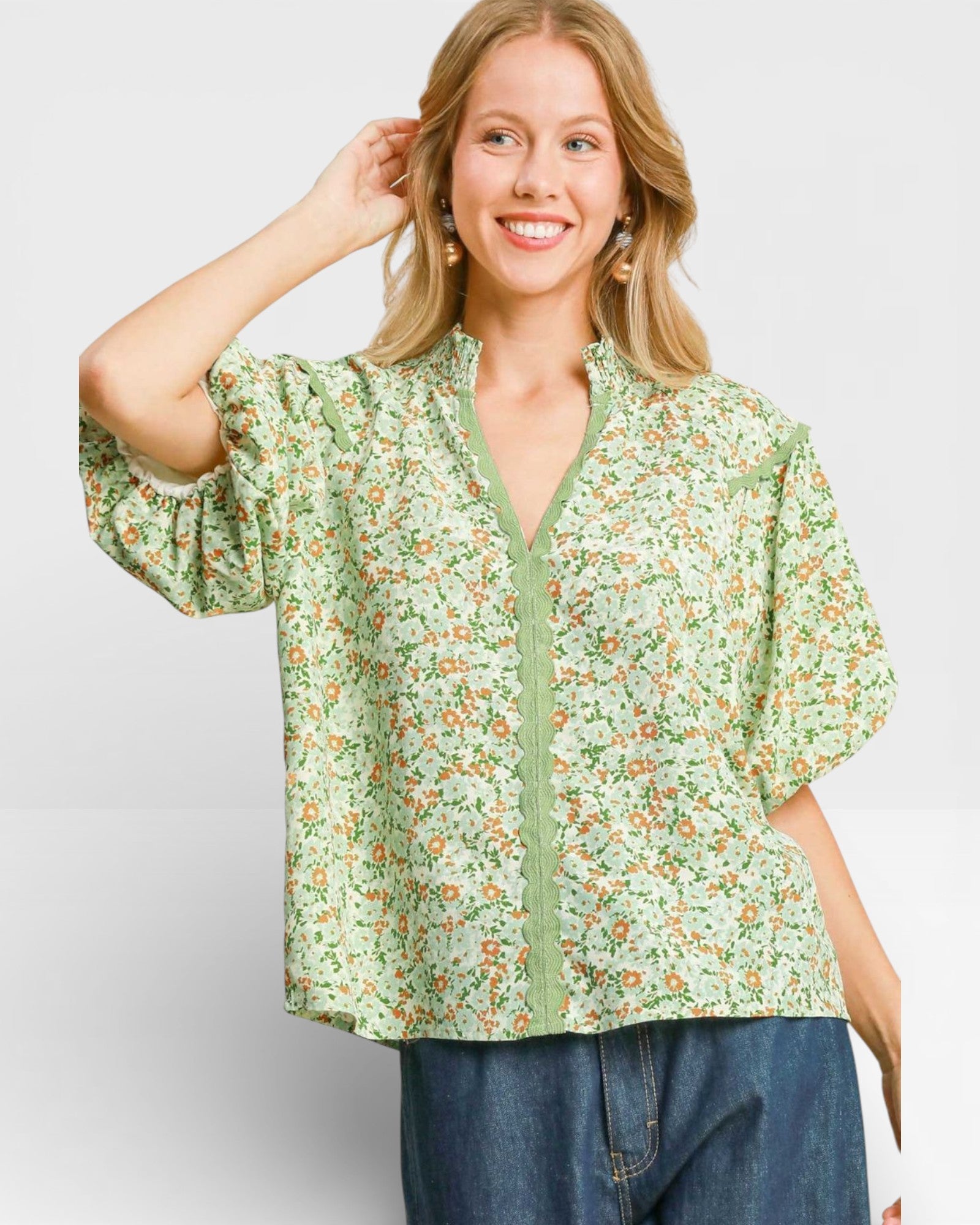 Woman wearing a green floral blouse against a white background