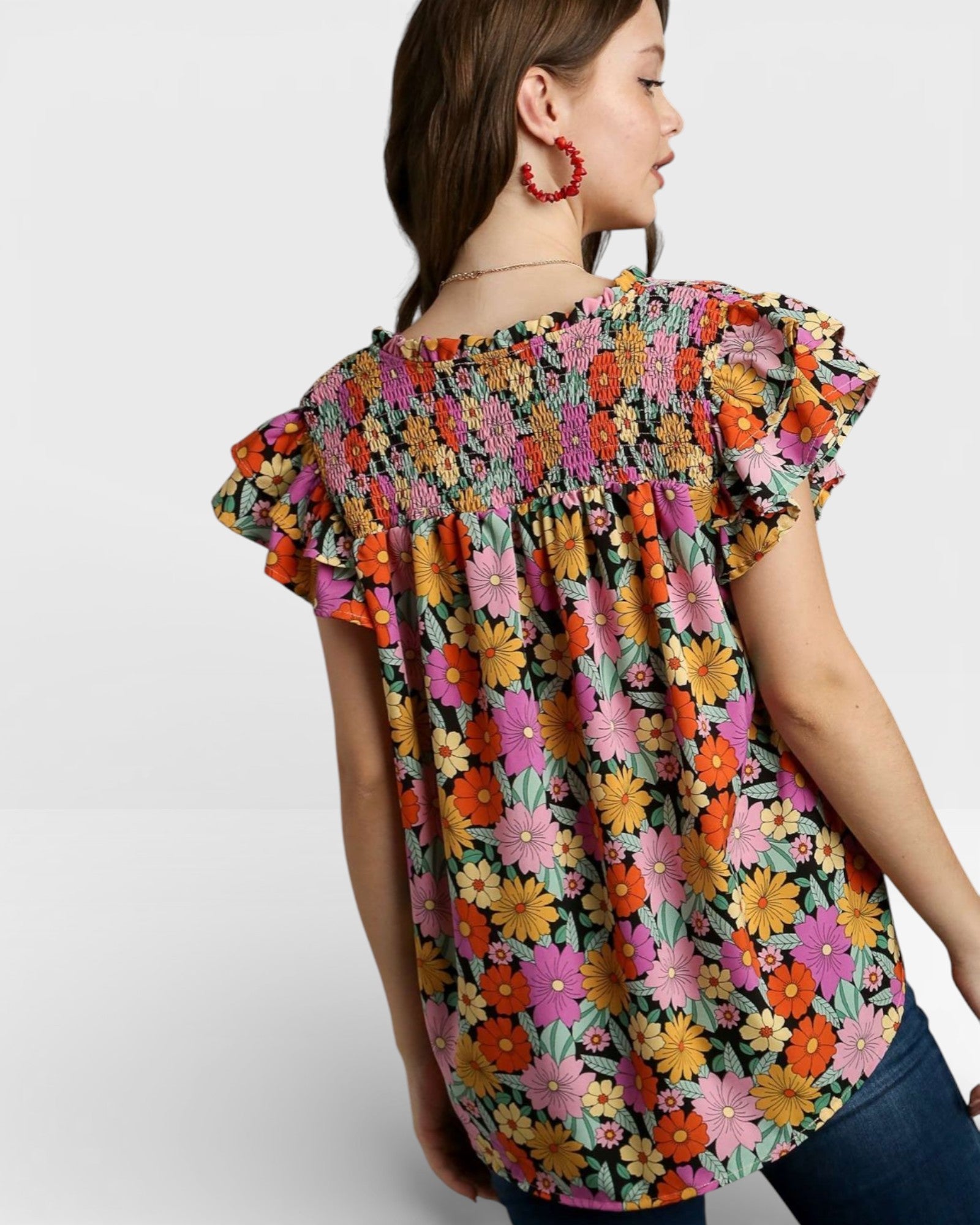 Woman wearing a colorful floral blouse on a white background