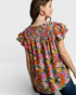 Woman wearing a colorful floral blouse on a white background