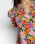 Colorful floral dress with ruffled sleeves on a plain background