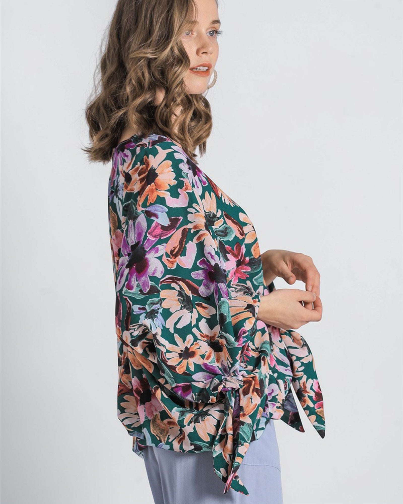 Woman wearing a colorful floral kimono against a white background