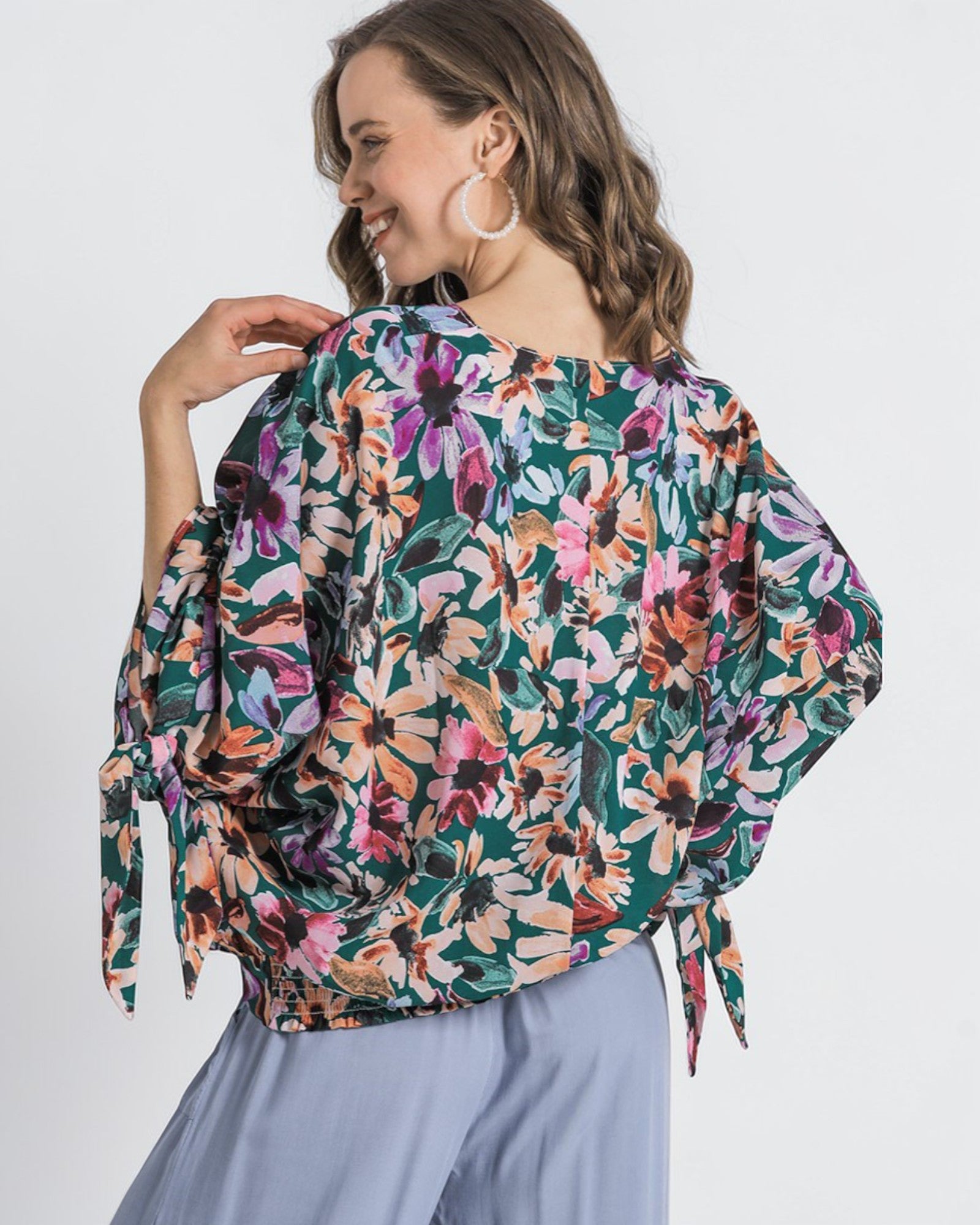 Woman wearing a colorful floral blouse with a white background