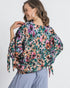 Woman wearing a colorful floral blouse with a white background