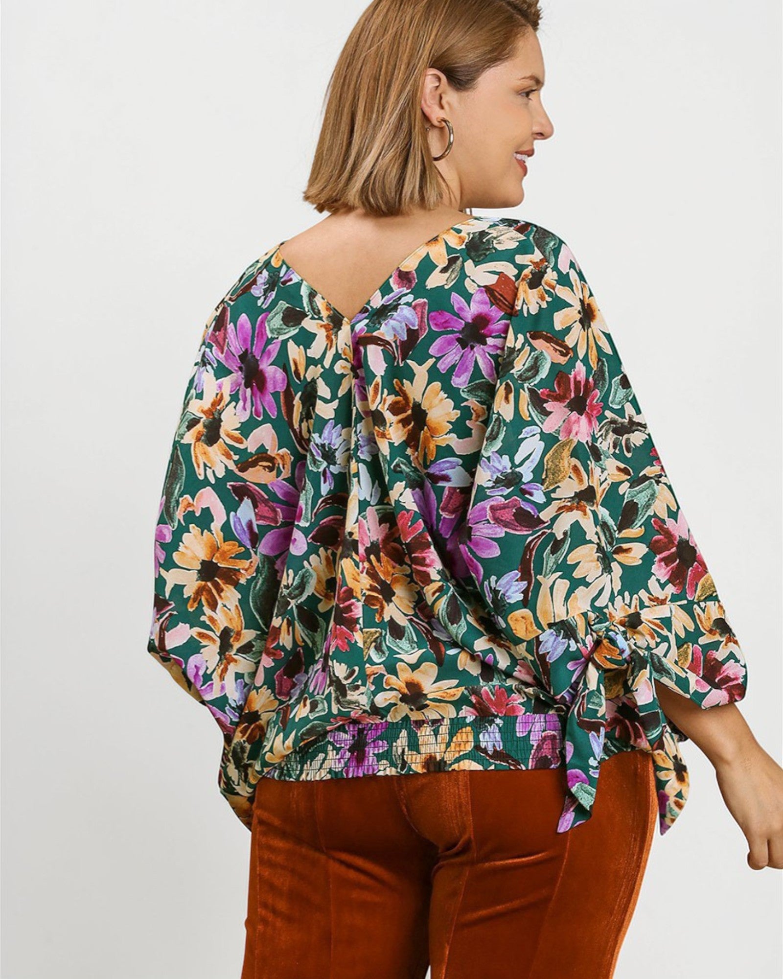 Woman wearing a floral blouse with a plain background