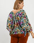 Woman wearing a floral blouse with a plain background