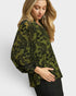 Woman wearing a green floral patterned top on a white background