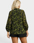 Person wearing a green floral patterned blouse on a white background