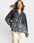 Woman wearing a black floral blouse with long sleeves on a white background