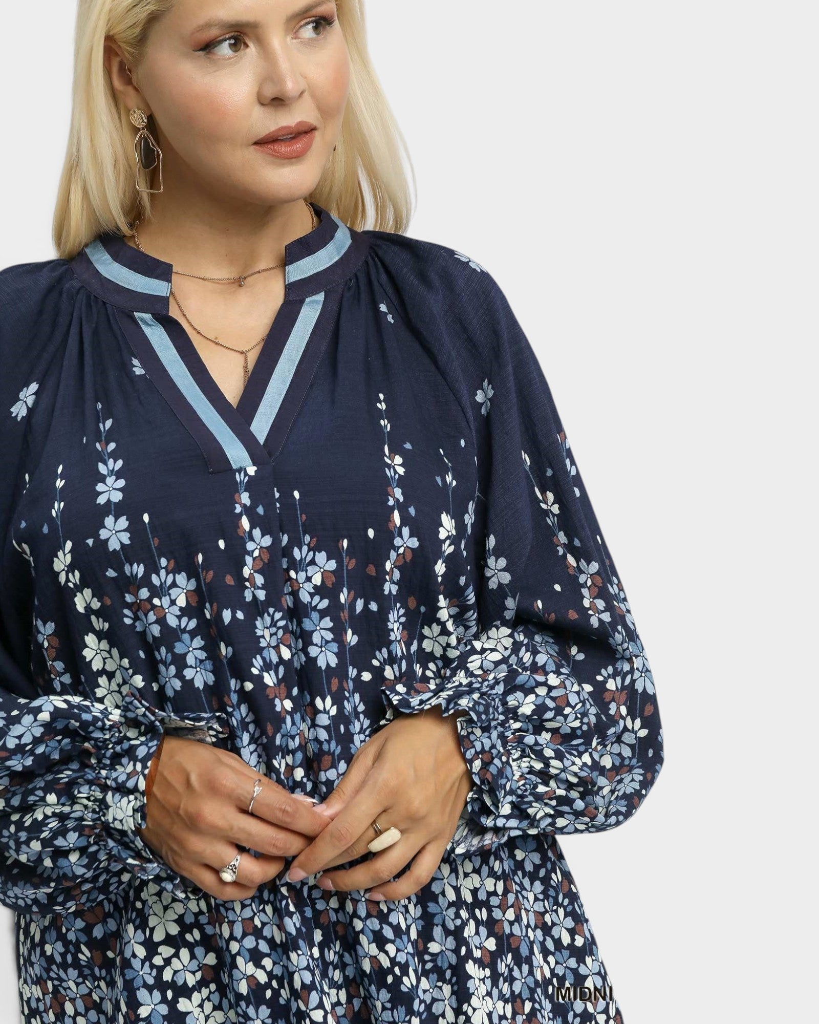 Woman wearing a navy floral dress on a white background
