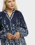 Woman wearing a navy floral dress on a white background