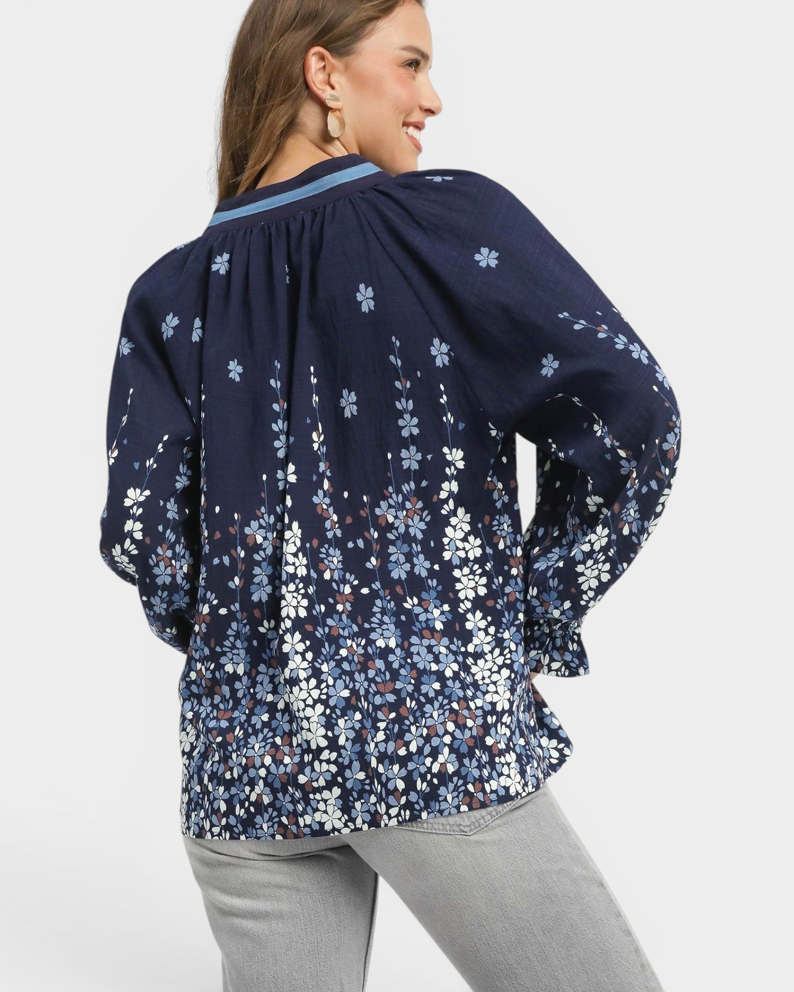 Woman wearing a navy floral blouse on a white background
