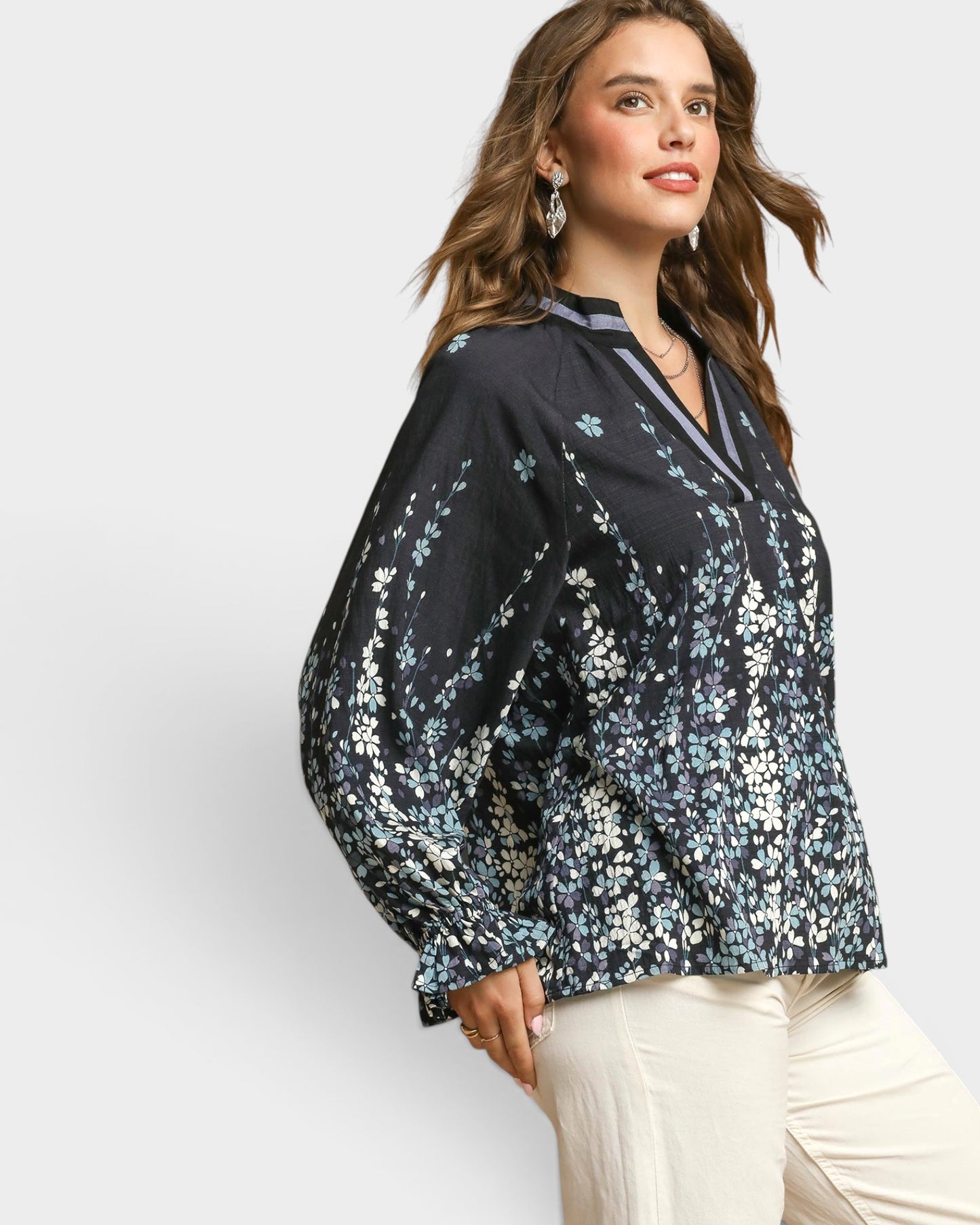 Woman wearing a black floral blouse against a white background