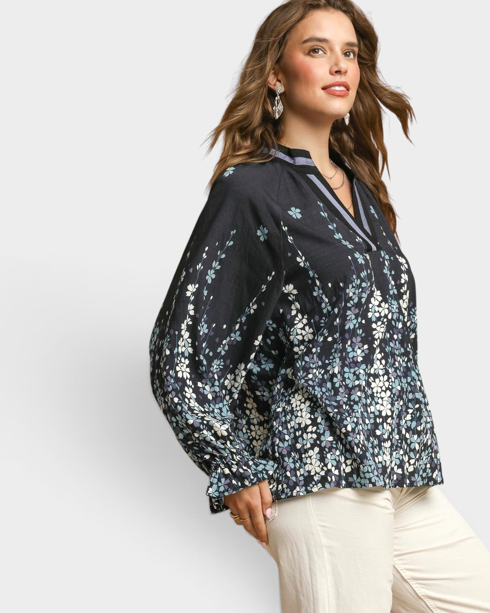 Woman wearing a black floral blouse against a white background