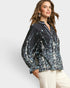 Woman wearing a black floral blouse against a white background