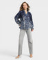 Woman wearing a blue floral blouse and gray pants on a white background