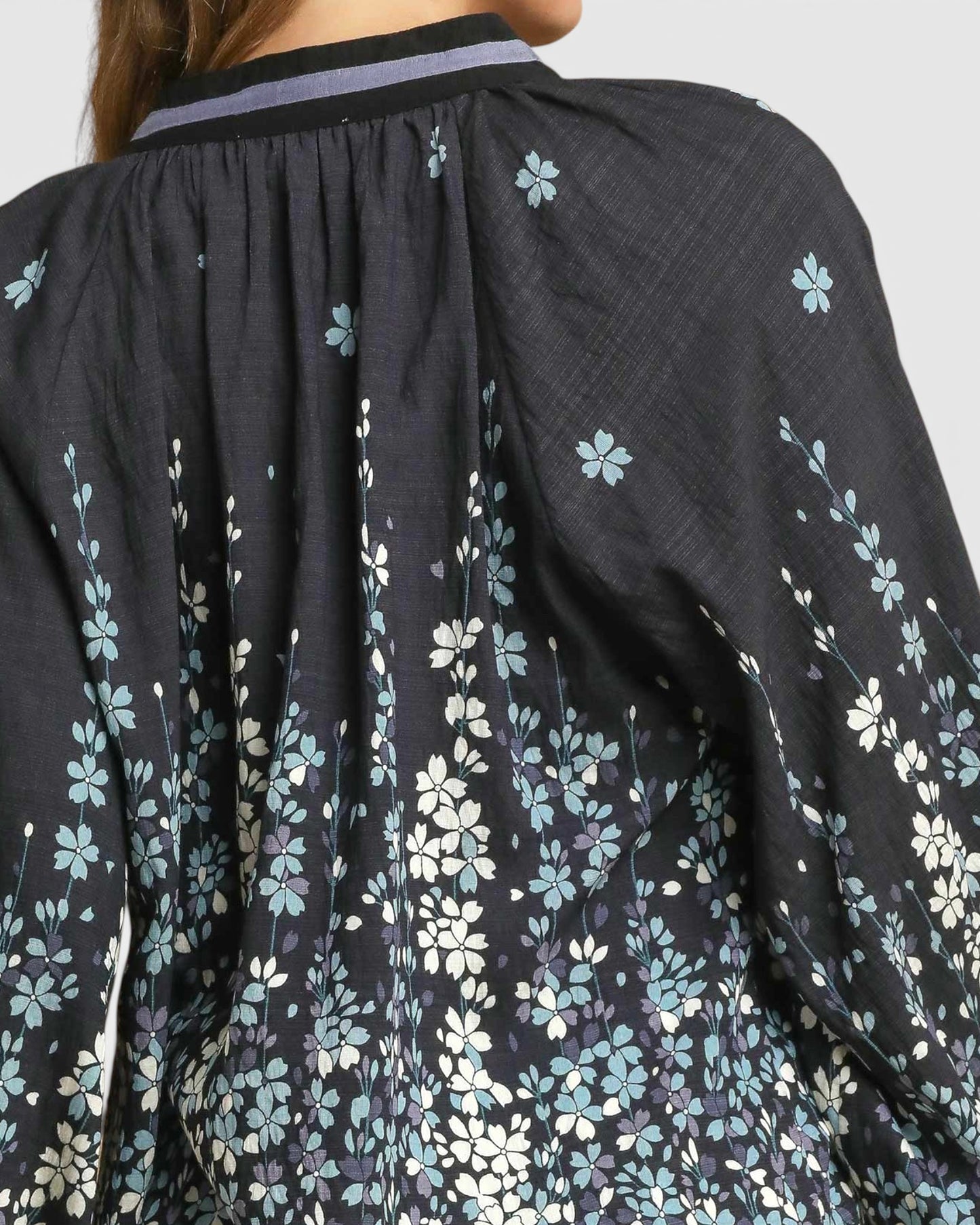Black floral-patterned garment with a close-up view of the fabric texture.