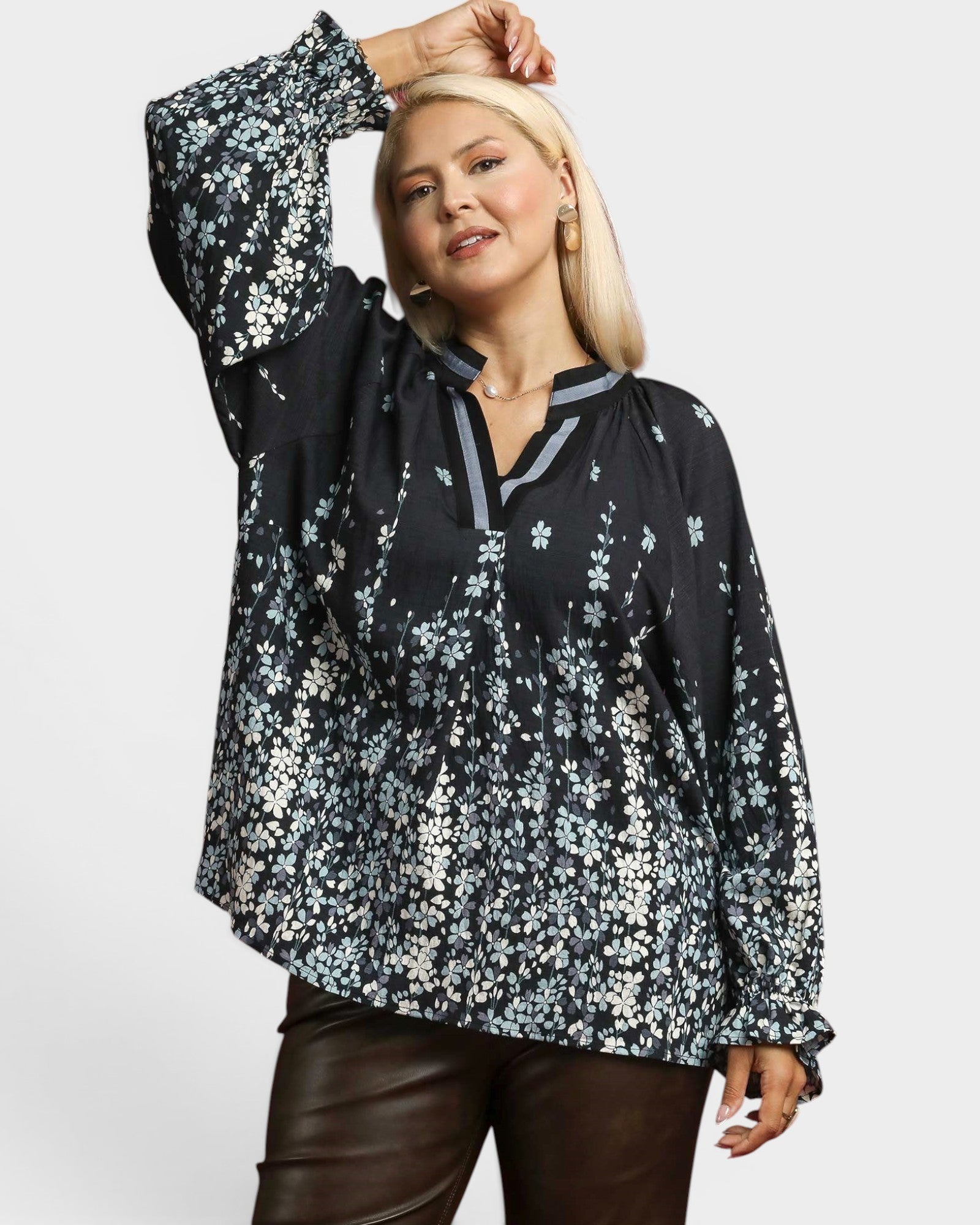 Woman wearing a black floral blouse on a white background