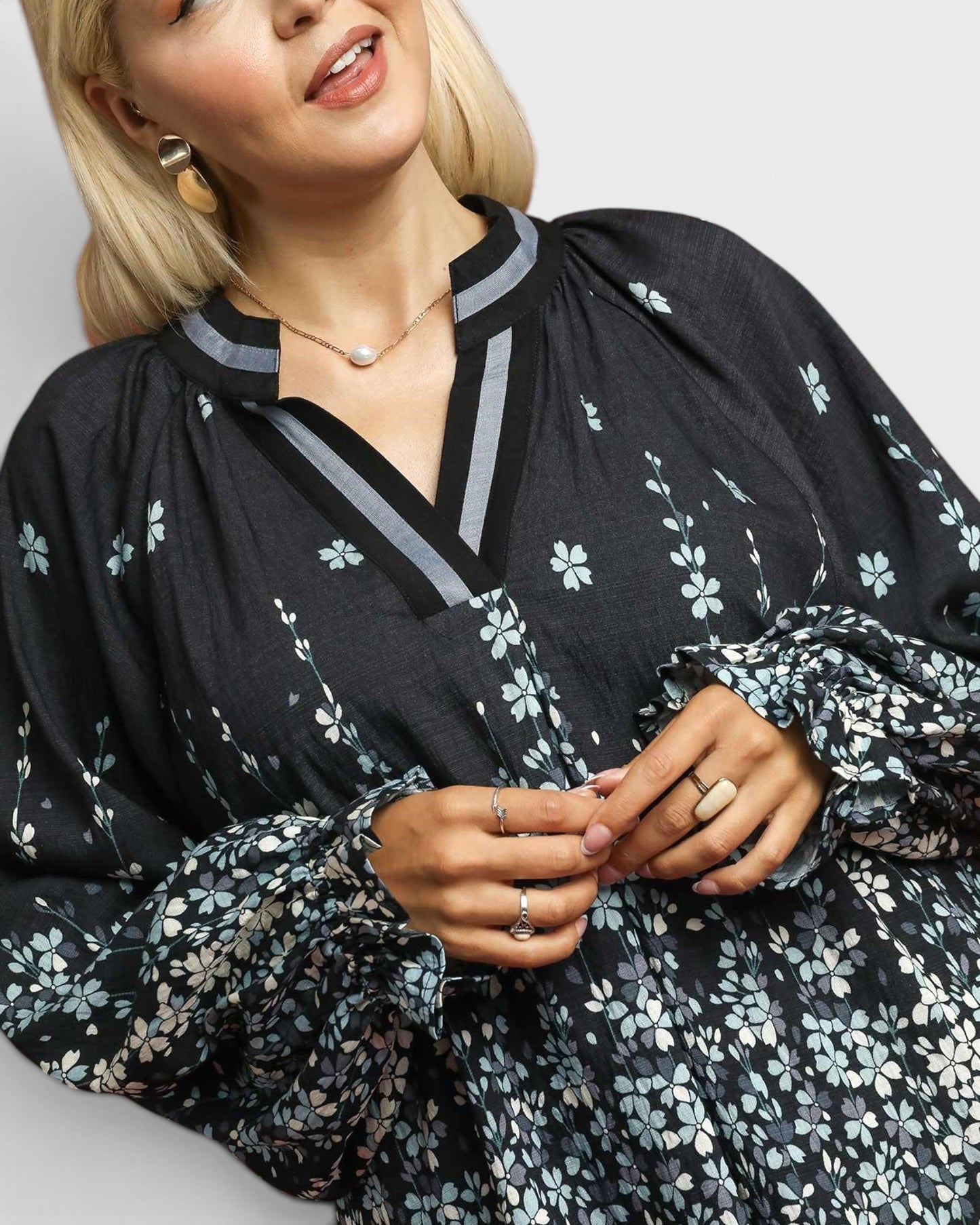 Woman wearing a black floral dress with a plain background