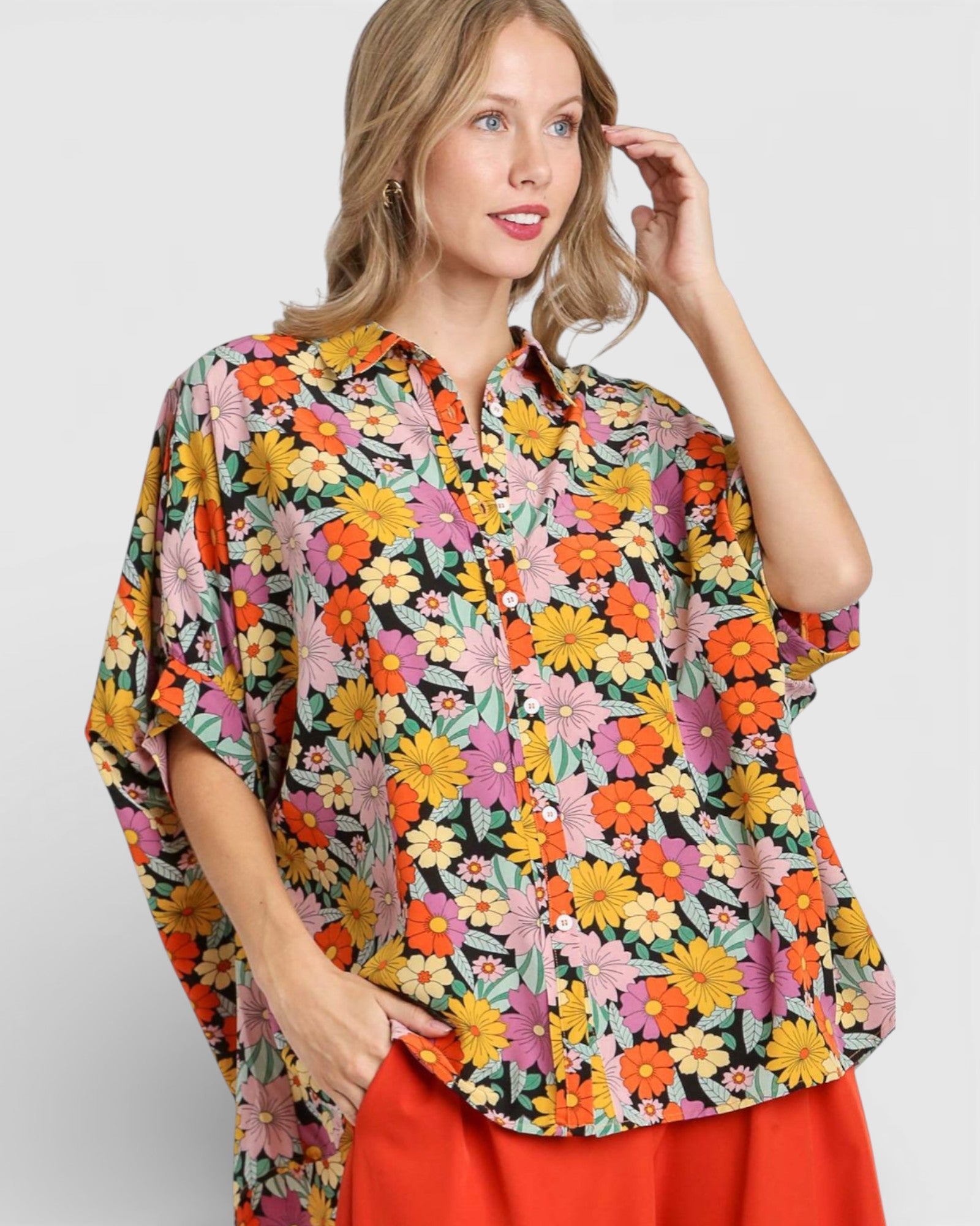 Woman wearing a colorful floral blouse with a plain background