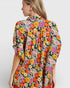 Woman wearing a colorful floral dress on a white background