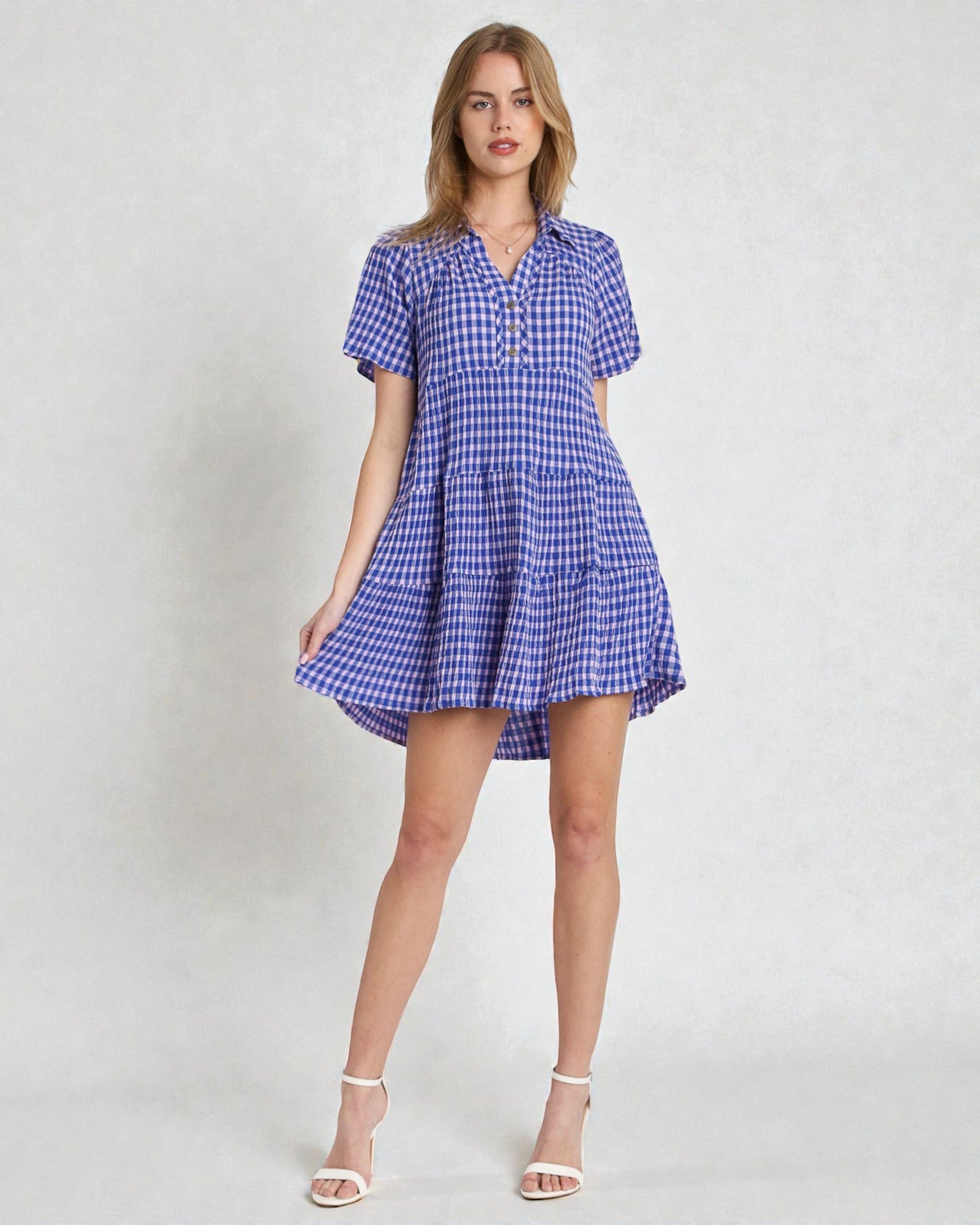 Woman wearing a blue checkered dress on a white background
