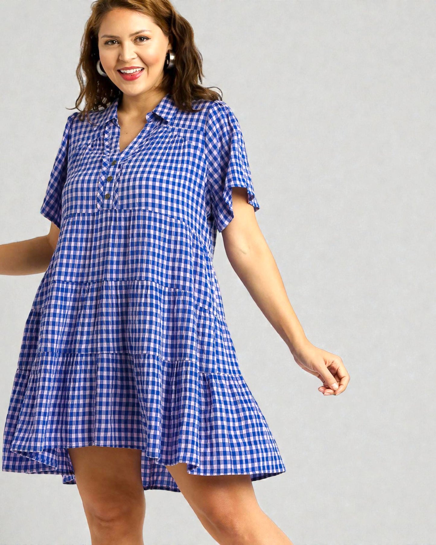 Woman wearing a blue and white checkered dress on a gray background