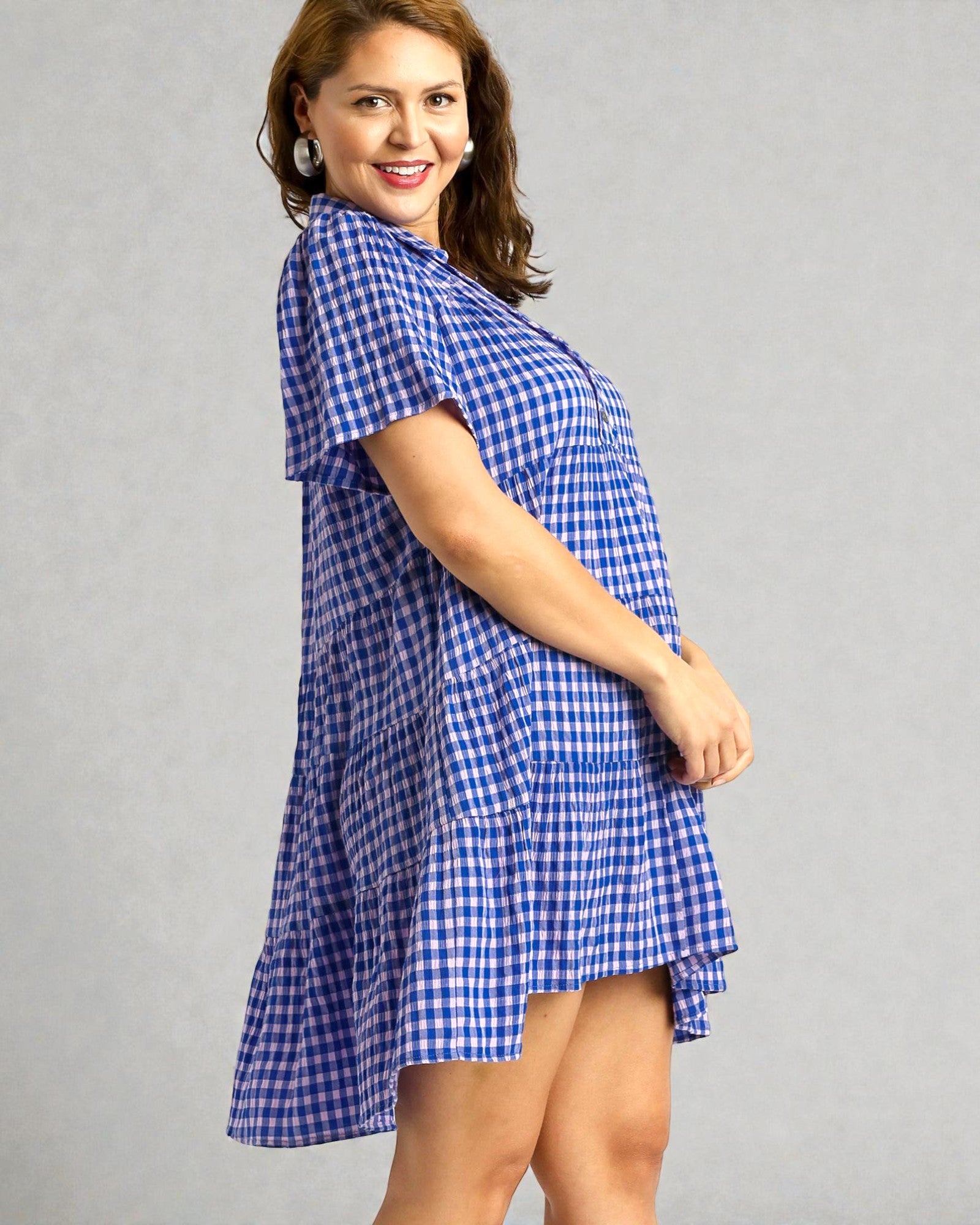 Woman wearing a blue checkered dress against a gray background