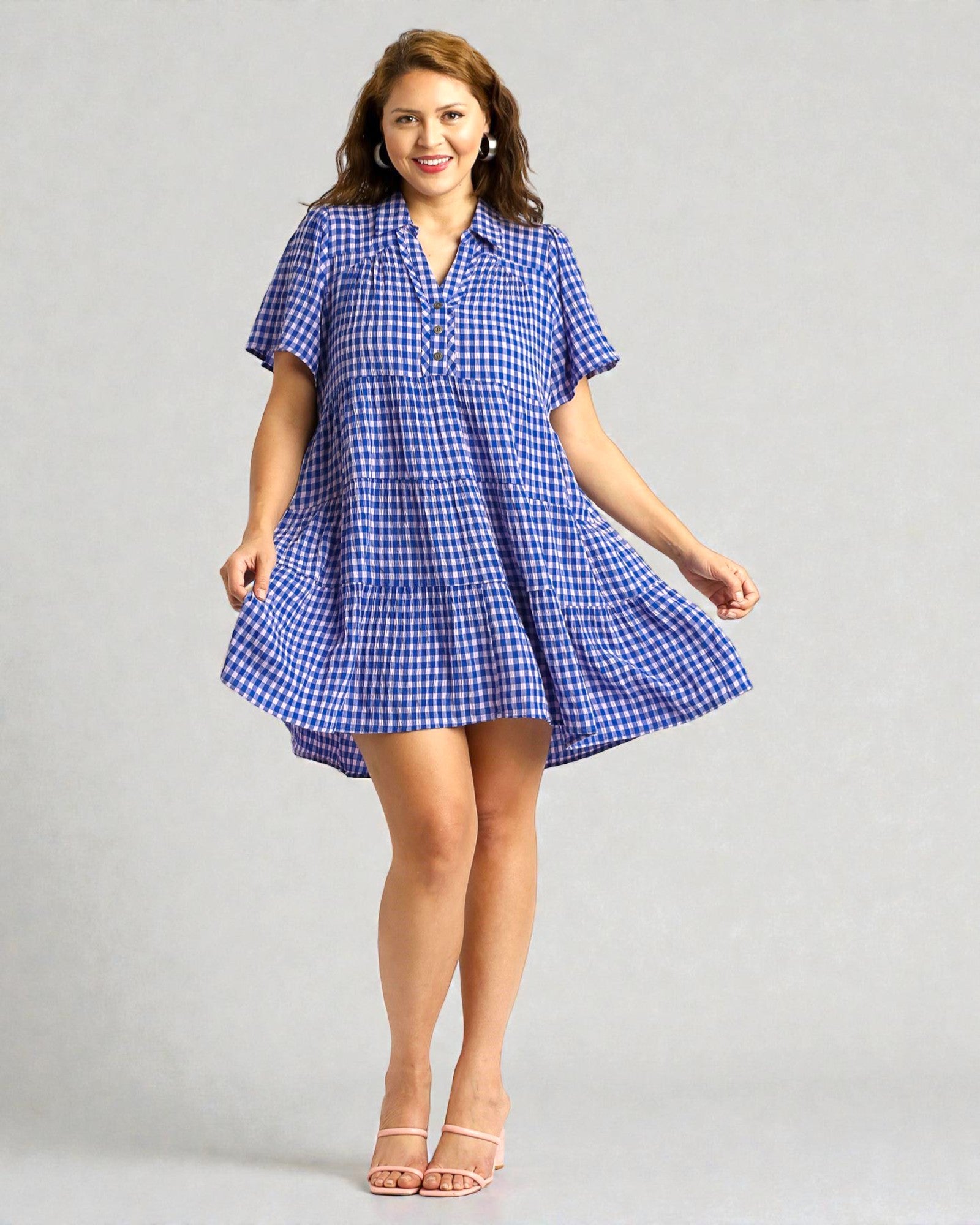 Woman wearing a blue checkered dress on a gray background