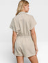 Woman wearing a beige romper on a white background