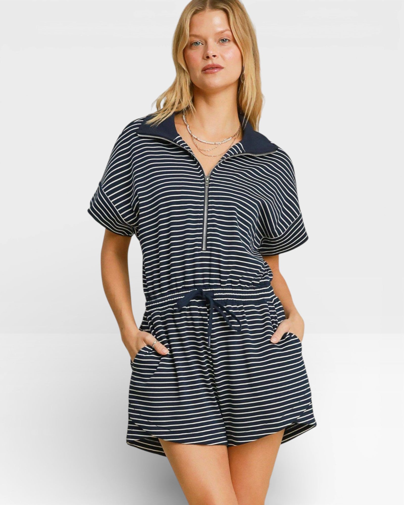 Woman wearing a navy and white striped dress with a collar on a white background