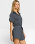 Woman wearing a navy and white striped dress on a light gray background