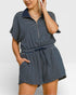 Woman wearing a navy and white striped dress on a plain background
