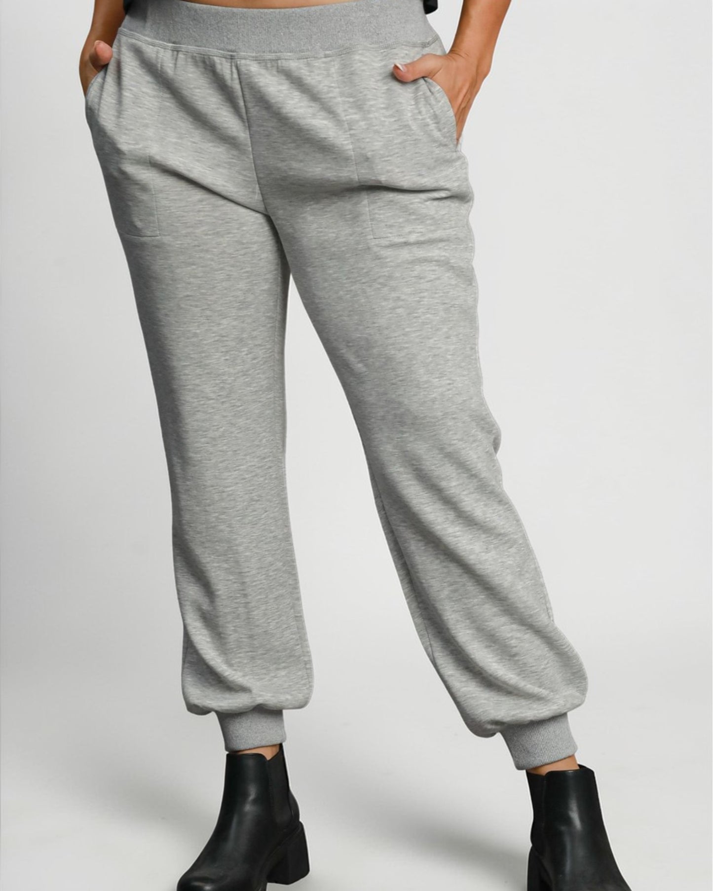 Gray sweatpants worn by a person on a plain background