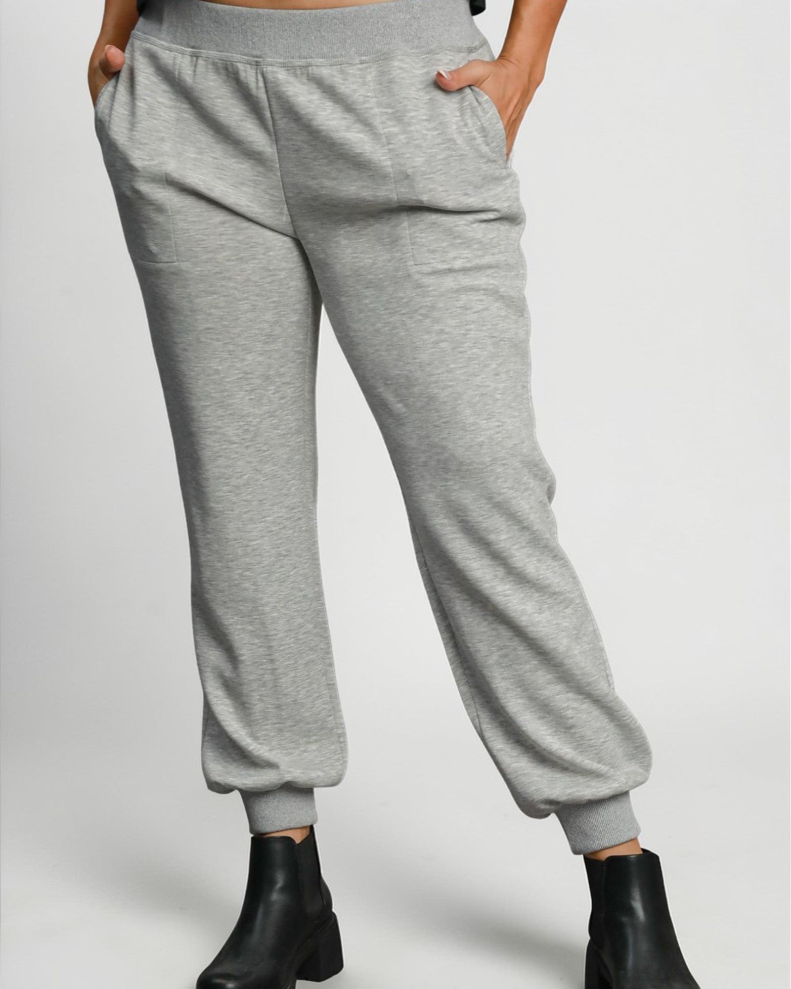 Gray sweatpants worn by a person on a plain background