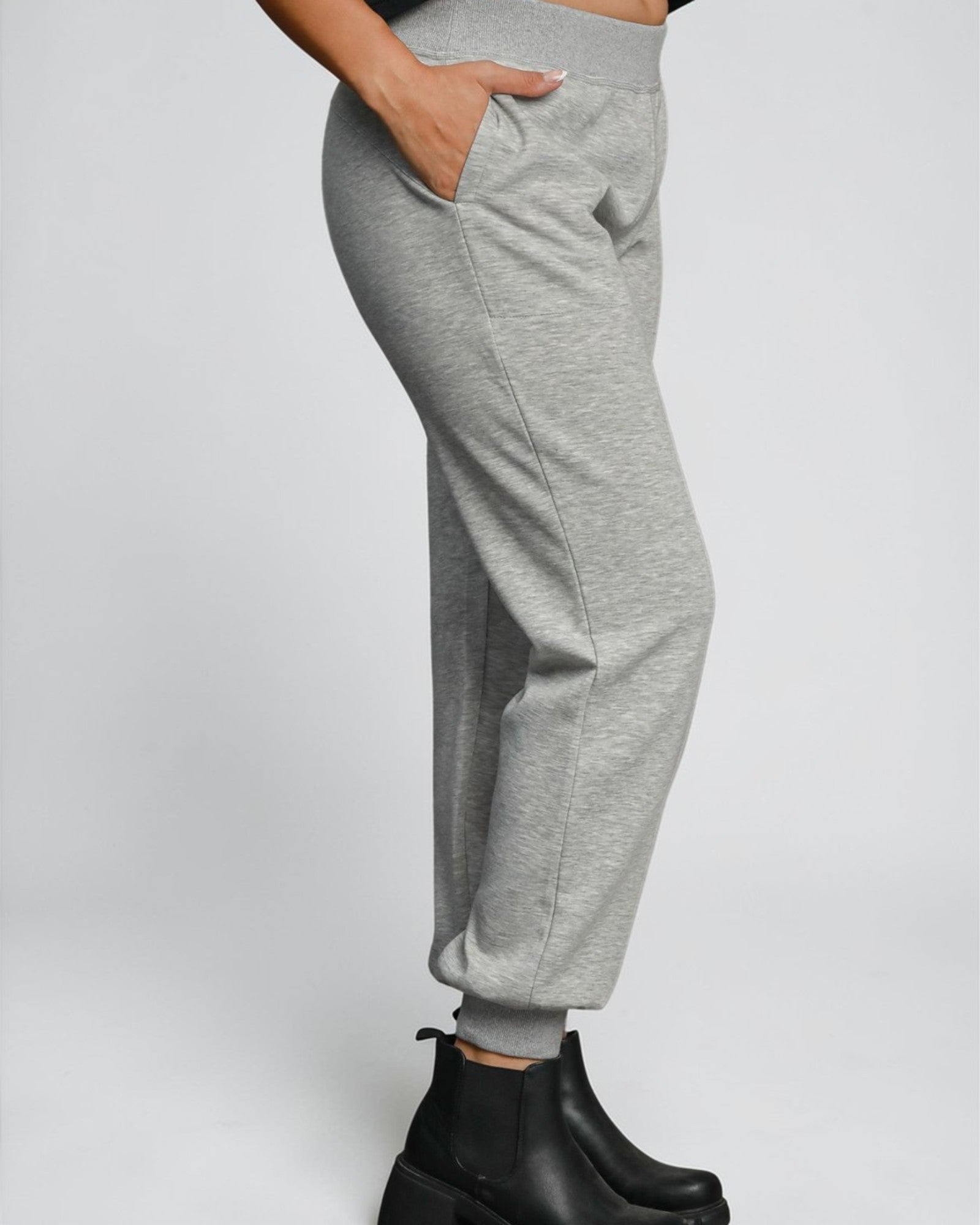 Gray sweatpants worn by a person on a white background