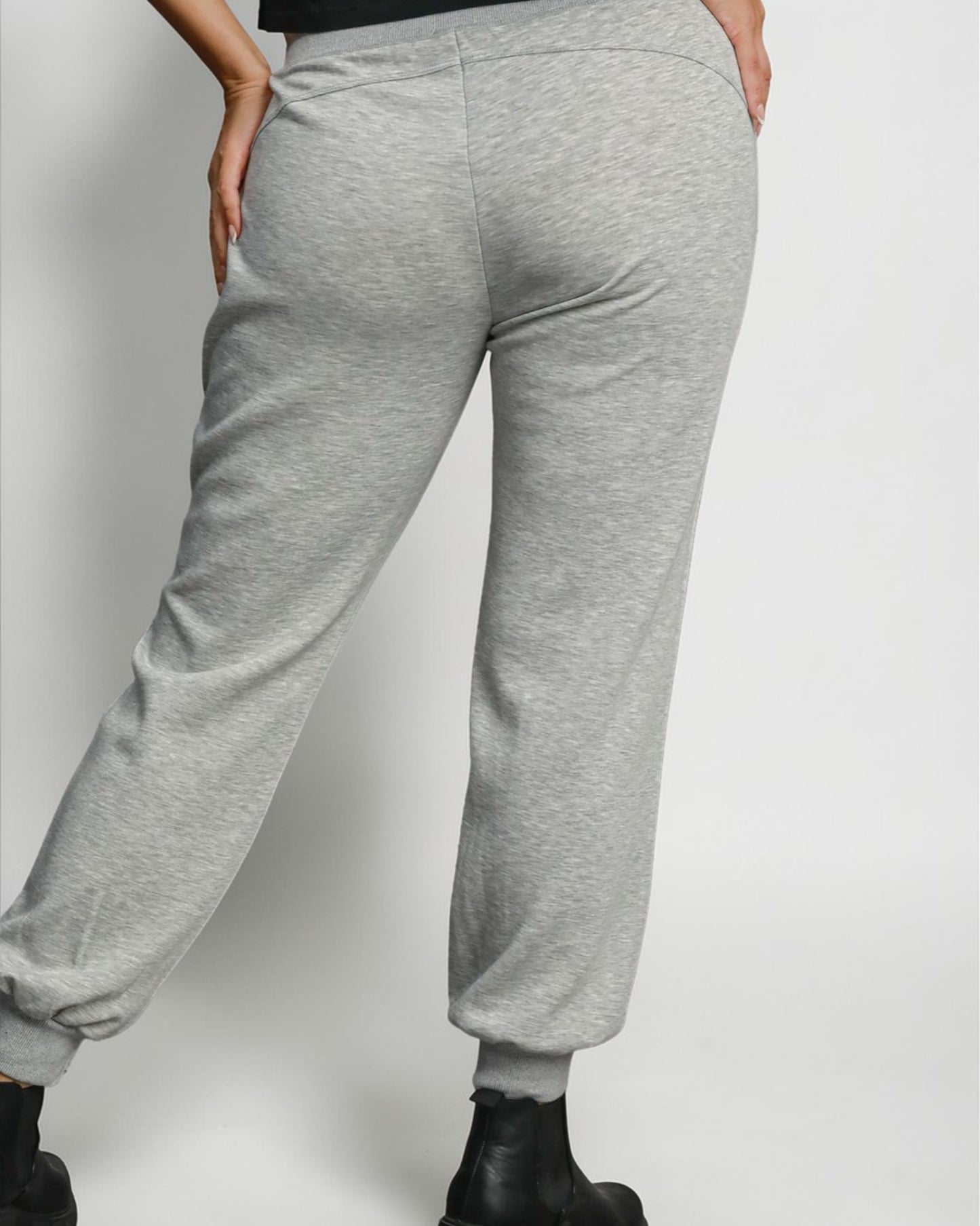 Gray sweatpants worn by a person on a plain background