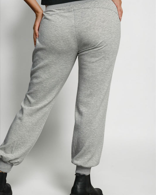 Gray sweatpants worn by a person on a plain background